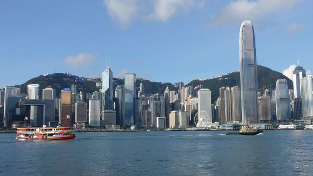 Hong Kong skyline at sunrise in morning.  View of Kowloon pier, avenue of stars in Tsim Sha Tsui.  Victoria Harbour, Central, Causeway Bay cityscape. Passenger cargo ship traffic transport. Time lapse