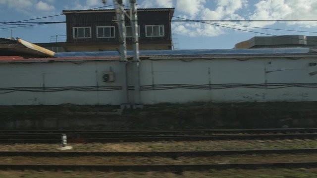 POV: High-speed train moves past an industrial zone