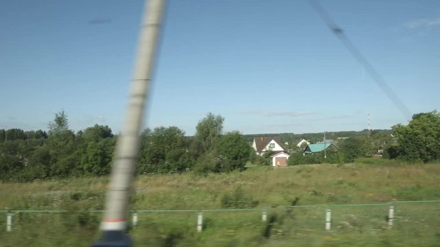 POV: High-speed Train moves near a village and fields