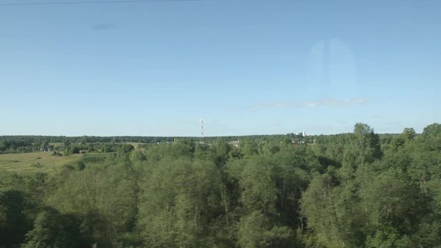 POV: High-speed Train moves near a village, fields and trees