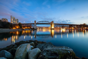 View on the sandy beach in Vancouver Downtown, BC, Canada, with False Creek, Burrard Bridge and buildings in the background.