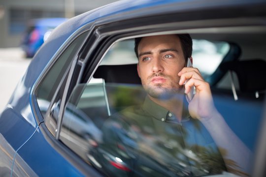 Man talking on mobile phone in car