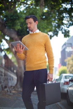 Man with briefcase using digital tablet