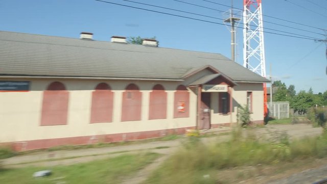 POV: High-speed Train moves past a small station in the summer