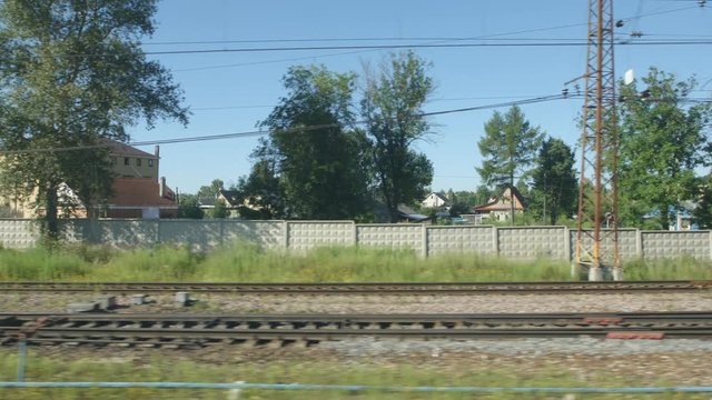POV: High-speed Train moves past a railway station in a small town