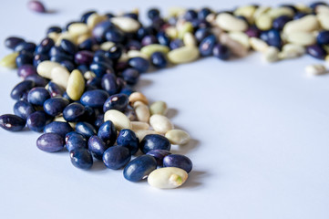 Lot of blue and green beans on a white background