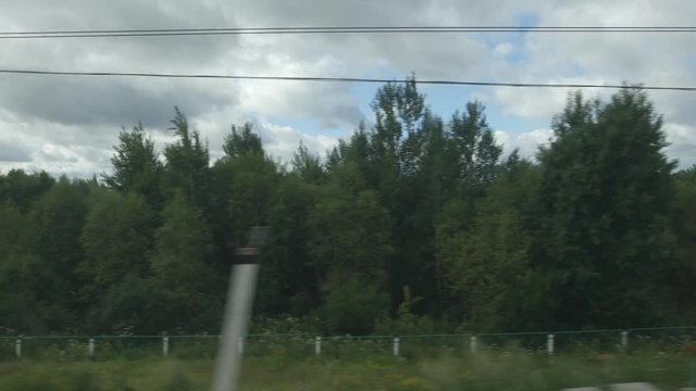 POV: High-speed Train fast moves on a bridge over a river in a cloudy day