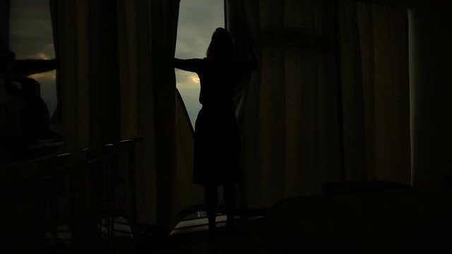 Woman unveil curtain from window during sunset, super slow motion 240fps 
