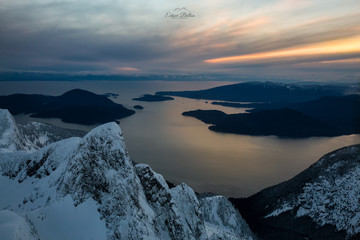 Beautiful aerial landscape of Howe Sound during a cloudy winter sunset. Picture taken north of Vancouver, British Columbia, Canada.