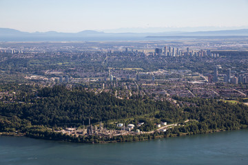 Aerial Cityscape View of Burnaby Mountain, Oil Refinery Plant, and Metrotown in the background. Taken in Vancouver, British Columbia, Canada.