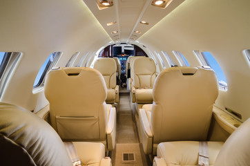 Luxury interior of genuine leather in the modern business jet and sunlight at the window