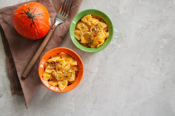Pumpkin creamy mac and cheese baked pasta over white stone background. Comfort food.