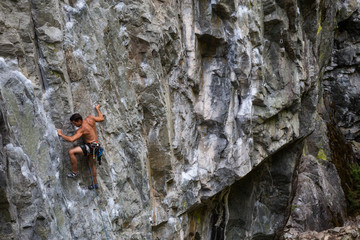 Rock climber climbing a steep rock face in Squamish, British Columbia, Canada.