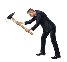 A businessman on white background raises a large hammer with a metal head and a wooden handle both...