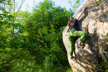 Climber is bouldering outdoors.
