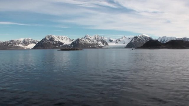 Water surface on background of snow mountains in Arctic Ocean Svalbard. Wildlife in Nordic badlands. Unique footage and natural landscape of Spitsbergen.