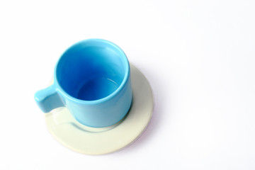 An empty blue cup with white plate isolated on white background.