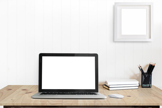 Front view picture of studio workplace with blank screen laptop and supplies. Designer comfortable work table, home studio office.