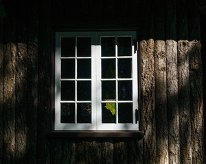 White window on the old wooden wall.