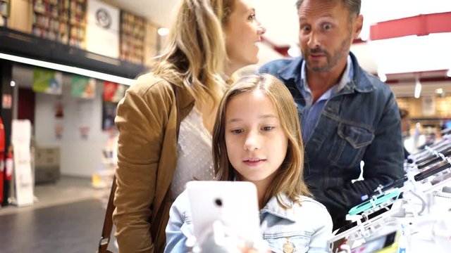 Family at the multimedia store looking at smartphones
