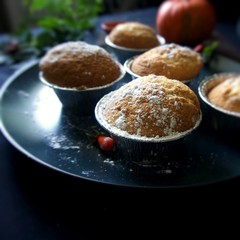 Homemade Lemon muffins with powdered sugar on a plate, on a dark background. Clothe up.