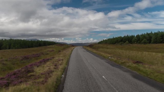 fast motion hyperlapse POV shot from a camera attached to the front of a vehicle driving through beautiful empty roads in the scottish highlands