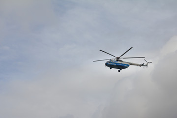 Fototapeta na wymiar Civil helicopter in cloudy sky