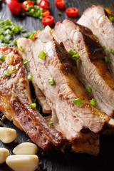 Spicy fried pork ribs with garlic and chili pepper close-up. Vertical