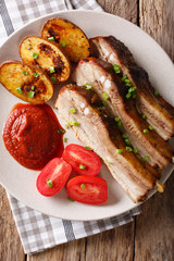 Fried pork ribs with sauce and tomatoes on close up.vertical top view