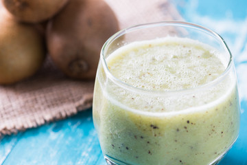 green kiwi juice, smoothie on wooden background. healthy drink in a glass. diet. summer drink and refreshment.