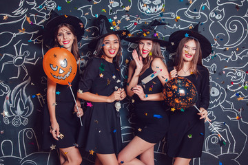 Beautiful girls in witches costumes on a dark background with a picture. Halloween.