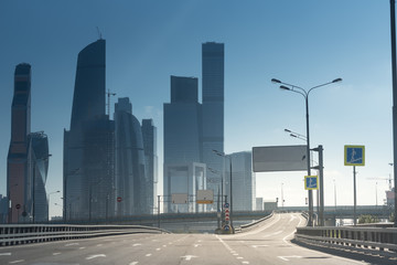 skyscrappers of a downtown and a huge empty highway under the sun. concept of strong financial performance and success.