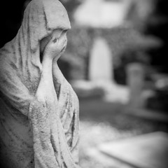 Statue of a sad woman in cemetery