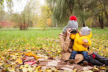 Young mother playing with little baby son and having fun happy family and love concept autumn background