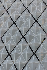 Grey polygonal pattern of a metal facade at the modern office building