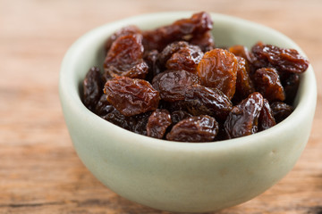 Raisins on a wood background.