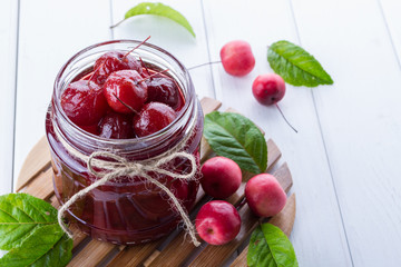 Delicious apple jam with whole apples on a white background.