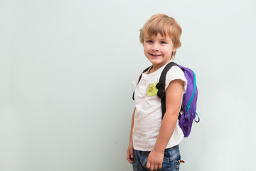 Cheerful smiling little kid with  backpack. 