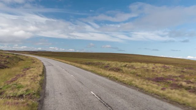 POV shot from a camera attached to the front of a vehicle driving through beautiful empty roads in the scottish highlands