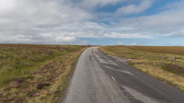 POV shot from a camera attached to the front of a vehicle driving through beautiful empty roads in the scottish highlands