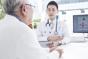 Fototapeta premium A young doctor is examining an old man