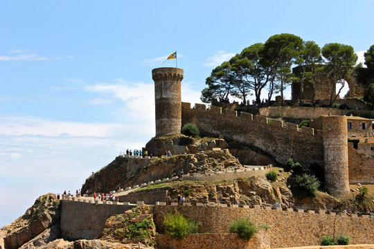 A Senyera estelada, the unofficial flag typically flown by Catalan independence supporters, waving on the tower of Tossa de Mar Fortress, Catalonia, Spain