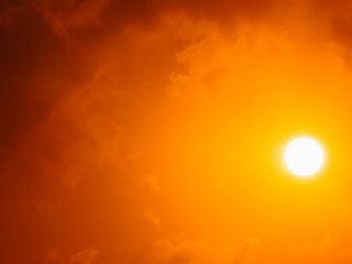 Sun up high in the sky with clouds in red and orange atmosphere