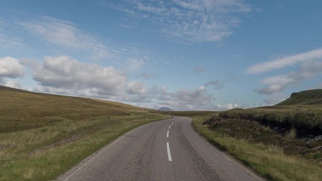 POV shot from a camera attached to the front of a vehicle driving through beautiful empty roads in the scottish highlands