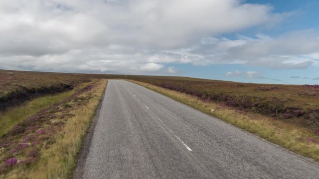 POV shot from a camera attached to the front of a vehicle driving through beautiful empty roads in the scottish highlands