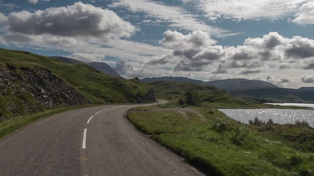 POV shot from a camera attached to the front of a vehicle driving through beautiful empty roads in the scottish highlands