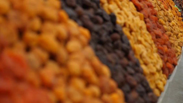 Spices, nuts, dried fruits on display at market on the counter, 4k, slow-motion
