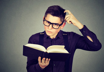 Confused man in glasses perplexed after reading a book