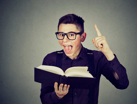 Excited young guy with book has a good idea