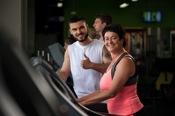 Fototapeta na wymiar Male personal trainer with female client in gym